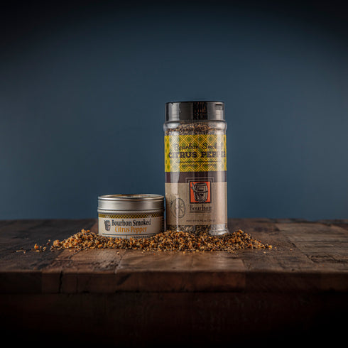 Bourbon Barrel Foods Bourbon Smoked Citrus Pepper in a shaker and a tin.
