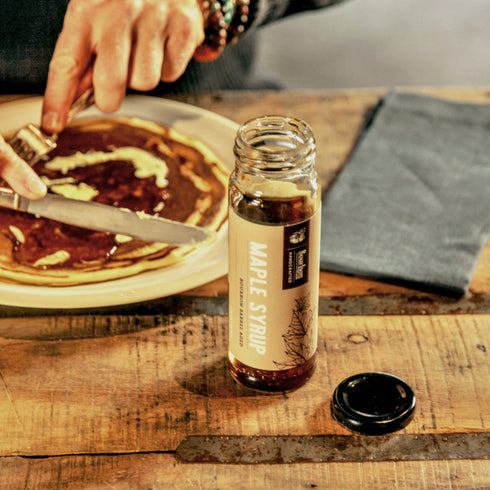 Bourbon Barrel Foods Bourbon Barrel Aged Maple Syrup on a pancake and in a bottle.