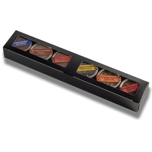 Black box with six small containers of different types of tea on a white background