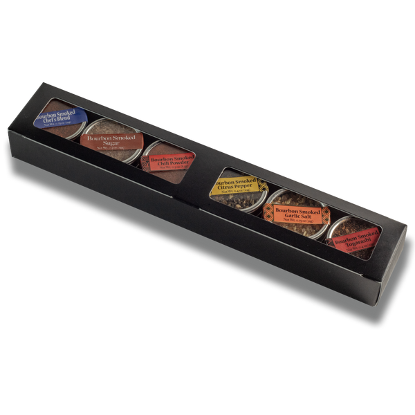 Black box with six small containers of different types of tea on a white background