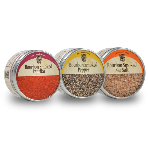 Three tins of bourbon smoked spices on a white background - Bourbon Barrel Foods Bourbon Smoked Paprika, Bourbon Smoked Pepper, Bourbon Smoked Sea Salt.