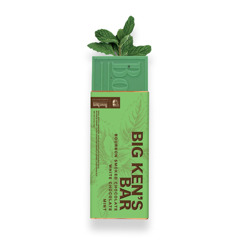 A boxed chocolate bar package on a white background, with a mint green chocolate bar partially visible above the wrapper. The wrapper is light green and reads 'BIG KEN'S BAR' with flavor text 'Bourbon Smoked Chocolate White Chocolate Mint.