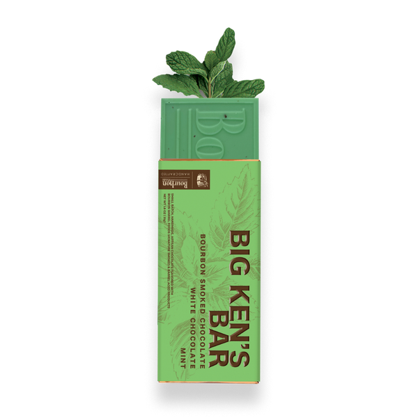 A boxed chocolate bar package on a white background, with a mint green chocolate bar partially visible above the wrapper. The wrapper is light green and reads 'BIG KEN'S BAR' with flavor text 'Bourbon Smoked Chocolate White Chocolate Mint.