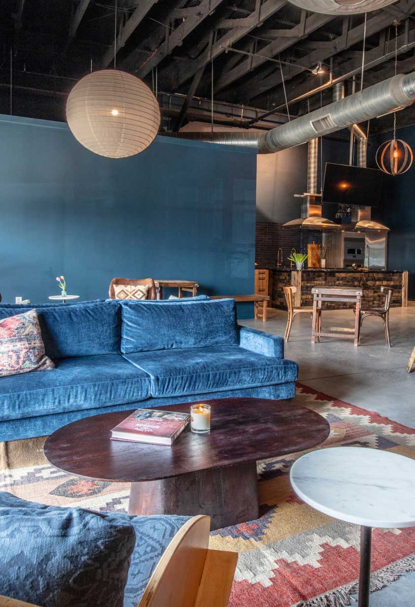 A well-lit lounge space with a sofa, coffee table, and chairs at Bourbon Barrel Foods retail space