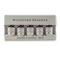 Woodford Reserve Bourbon Barrel Aged Bitters gift set in a beige presentation box, containing five small amber glass bottles with white labels.