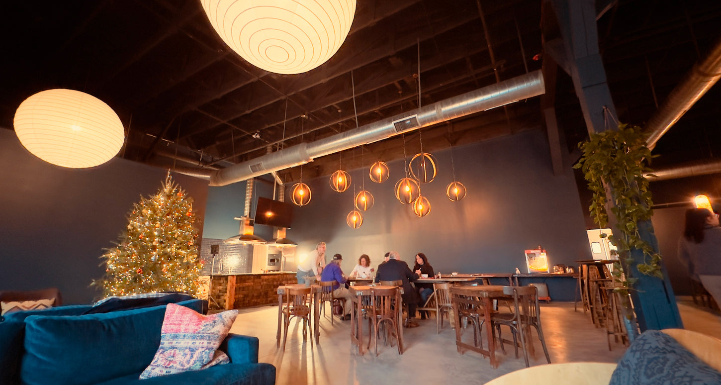 The Bourbon Barrel Foods event area decorated for Christmas with a Christmas Tree decorated in traditional warm white lights