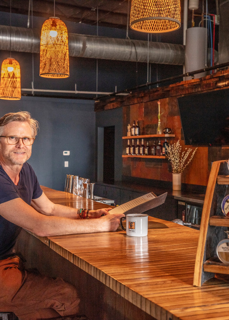 Matt Jamie sitting at the bar in Bourbon Barrel Foods retail space
