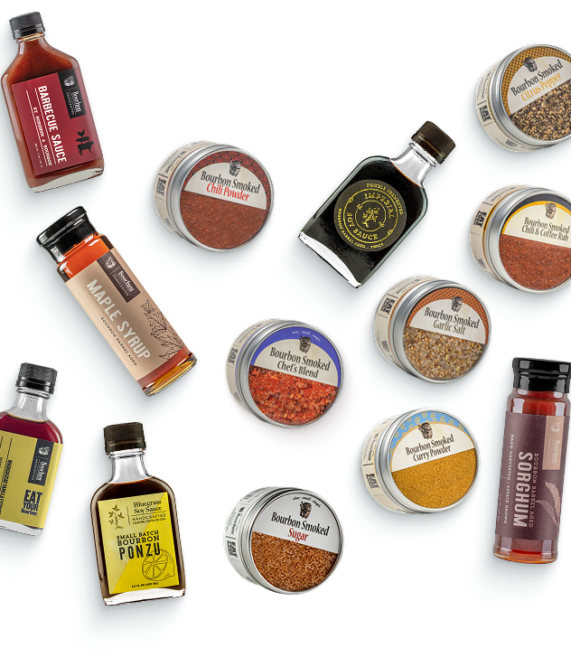 Gourmet Cooking Bundle: bourbon-aged sauces, smoked spices, and cooking-oil bottles scattered on a red-orange background