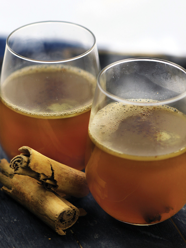 2 glasses of spiced cider with cinnamon sticks