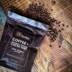 Bourbon Barrel Foods Coffee and Bourbon Smoked Cacao Nibs Coffee with coffee lifestyle with spilled bourbon barrel aged whole coffee beans.