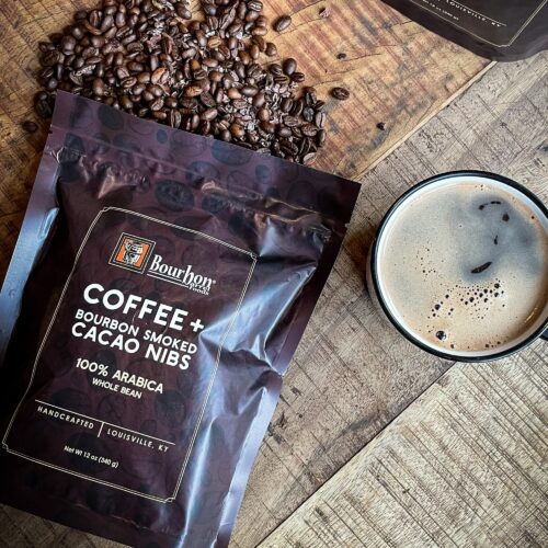 Bourbon Barrel Foods Coffee and Bourbon Smoked Cacao Nibs Coffee with coffee lifestyle with coffee and spilled bourbon barrel aged whole coffee beans.