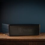 Bourbon Barrel Foods Branded Gift Box closed on a table with a blue background.